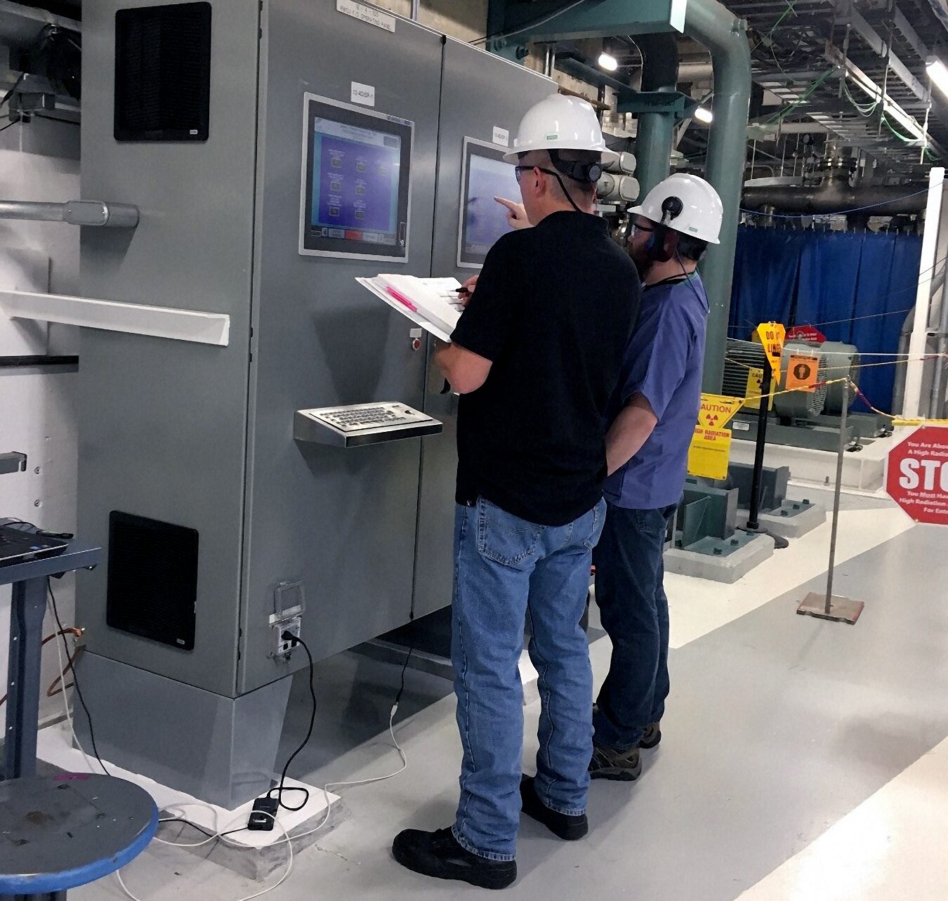 two men working on a PLC machine